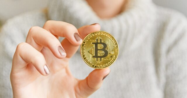 media-106820278-1609972654383-hand-holding-a-bitcoin-in-front-of-a-computer-screen-with-a-dark-graph-blockchain-mining-bitcoin_t20_prrrjp