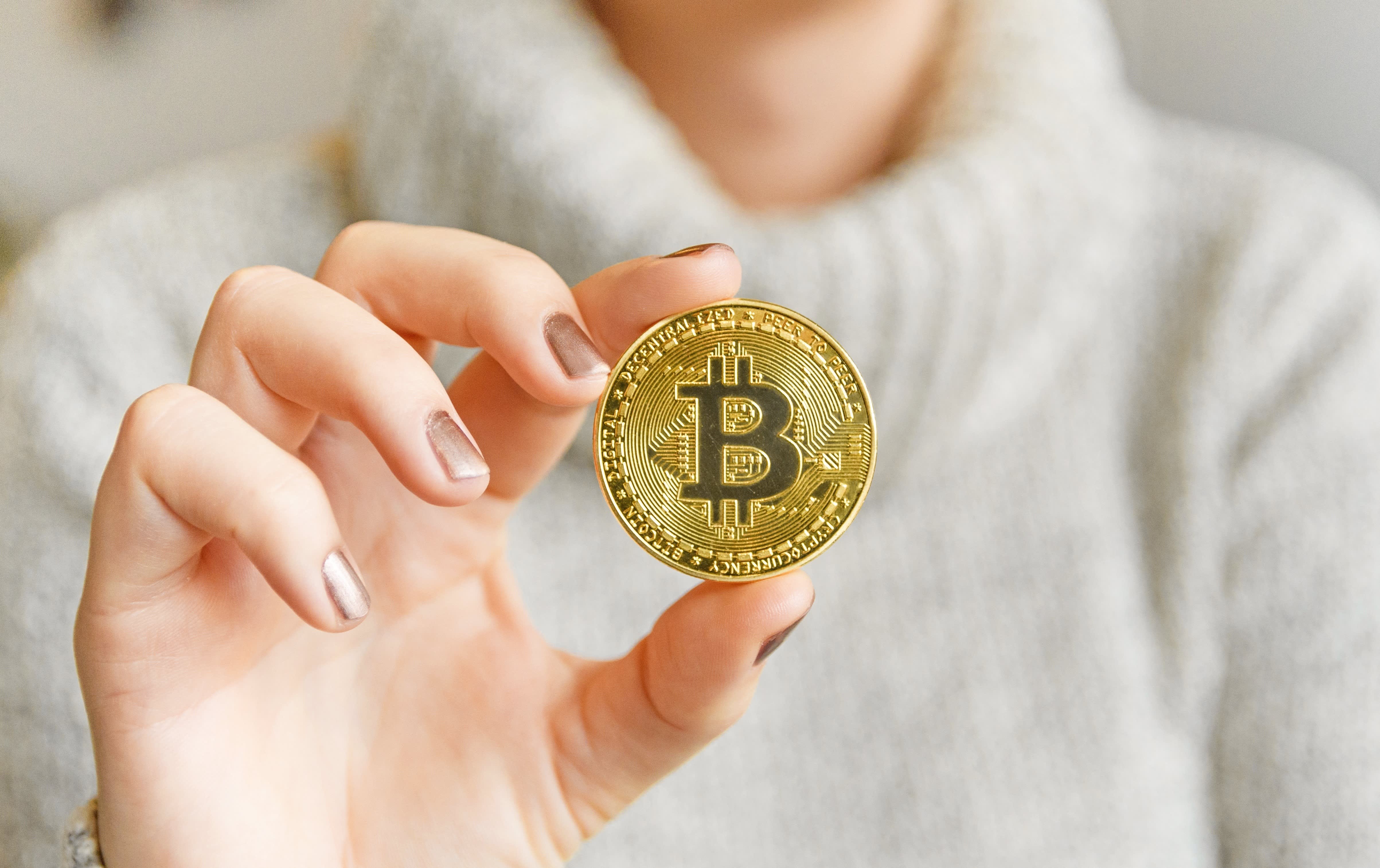 media-106820278-1609972654383-hand-holding-a-bitcoin-in-front-of-a-computer-screen-with-a-dark-graph-blockchain-mining-bitcoin_t20_prrrjp
